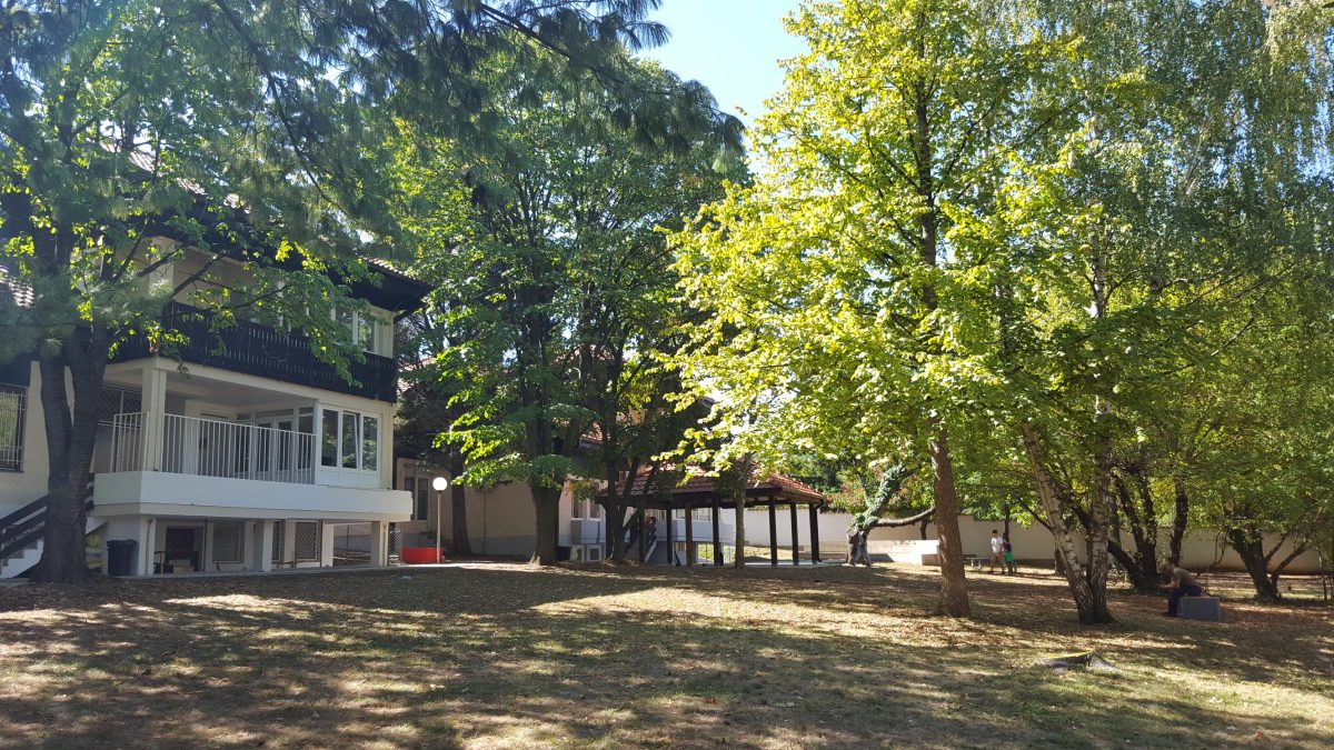 The school garden in Senjak, with the school buildings among tall trees