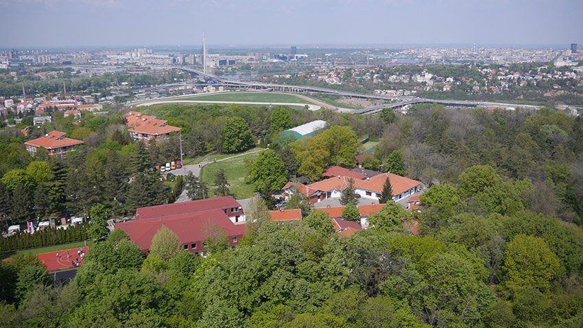 The school buildings among the trees of Košutnjak, with Belgrade in the distance