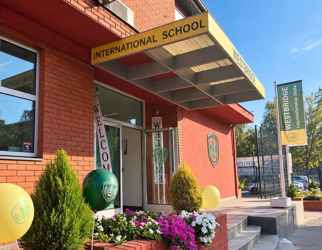 The school entrance under a yellow International School canopy, with welcome banners and balloons
